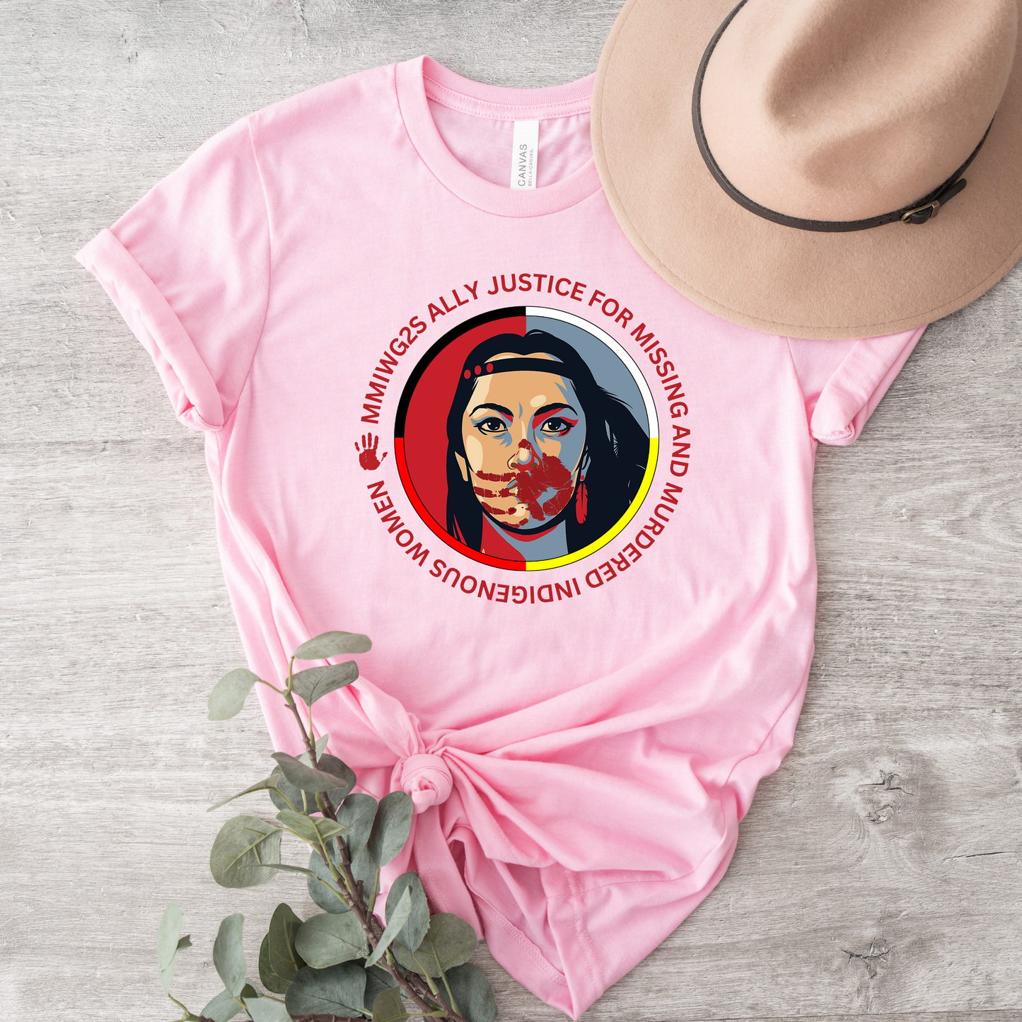 Pink t-shirt with a graphic design and text, placed on a wooden surface with a hat and plant. MMIWG2S shirt, Missing Murdered Indigenous Women tee, Indigenous ally shirt, MMIWG awareness apparel, justice for Indigenous women clothing, truth and reconciliation tee, National Day for Truth shirt, Indigenous activism clothing, 2SLGBTQQIA ally shirt, Canada missing women awareness, social justice tee, rally shirt Indigenous rights, solidarity shirt, awareness apparel Indigenous, activism t-shirt