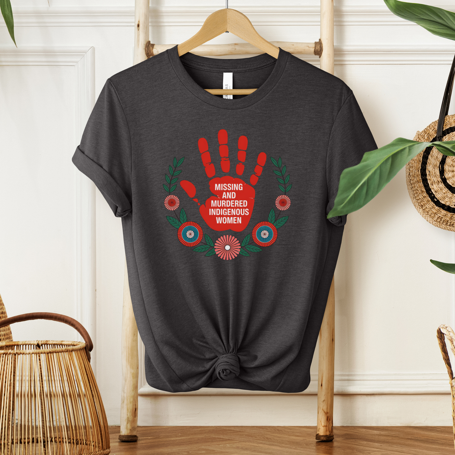 Black t-shirt with a red handprint design and text on a wooden hanger against a white wall. MMIW shirt, Missing and Murdered Indigenous Women shirt, red handprint shirt, Indigenous awareness shirt, Indigenous rights shirt, MMIW awareness tee, solidarity shirt, social justice shirt, unisex awareness shirt, Canada Indigenous shirt, Indigenous activism clothing, reconciliation shirt, advocate shirt, meaningful graphic tee, awareness apparel