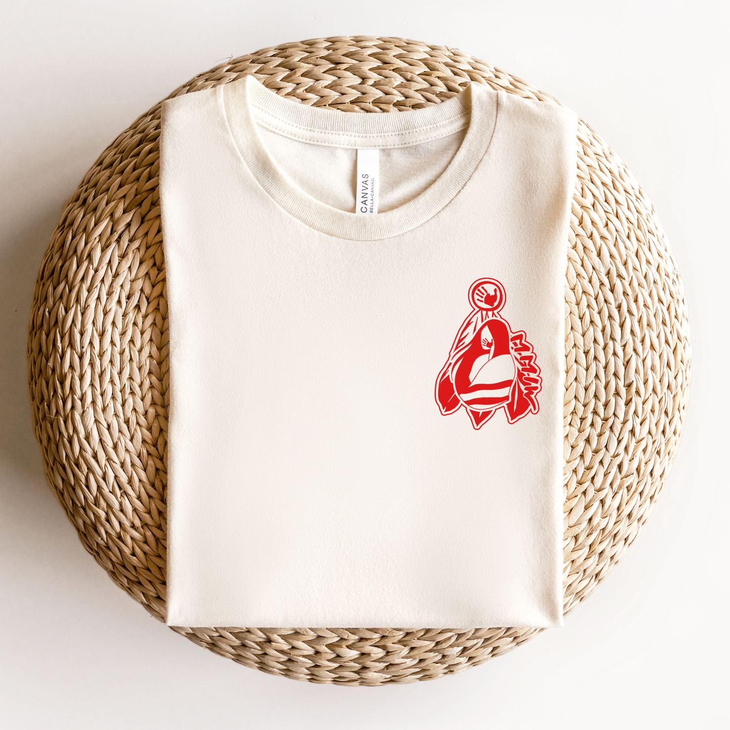 White t-shirt with red logo on a woven bal. MMIW shirt, MMIW woman in feathers, pocket design shirt, Indigenous awareness tee, Missing and Murdered Indigenous Women, Indigenous graphic tee, unisex t shirt, activism shirt, Indigenous justice, feather shirt, awareness apparel, Native shirt, statement tee, solidarity shirt, Indigenous owned brandl