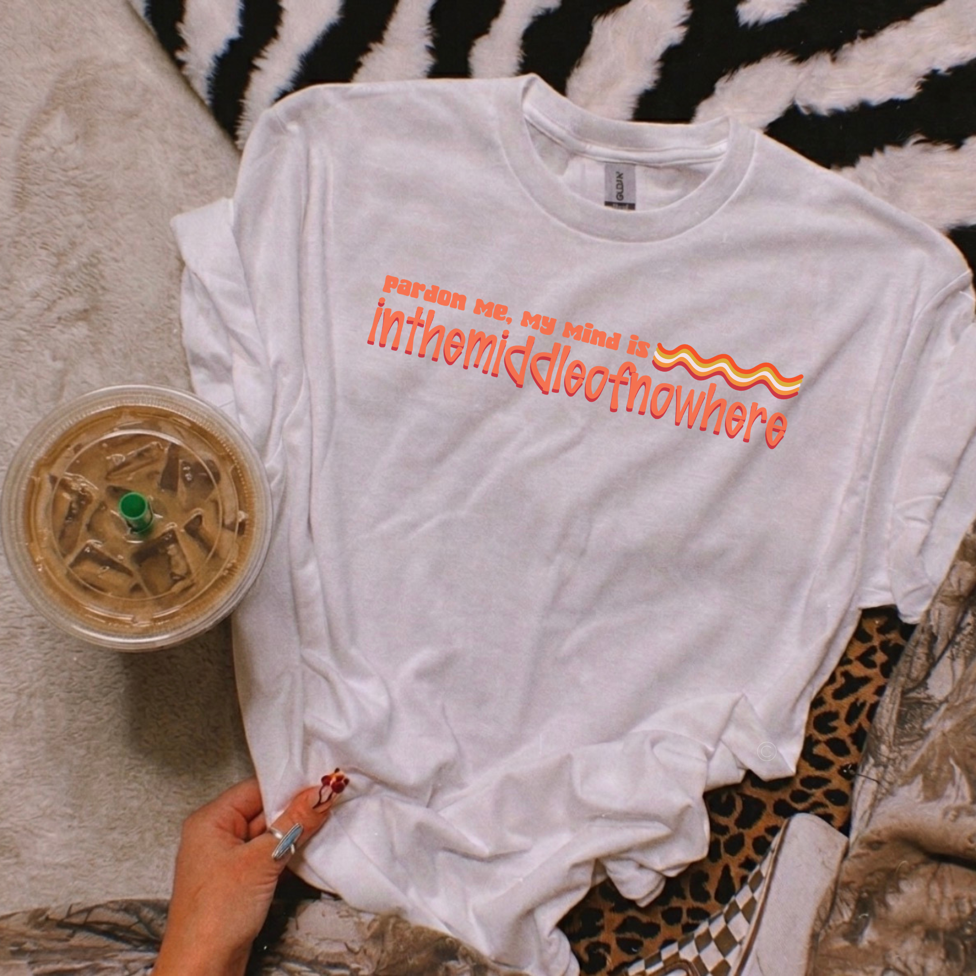 White t-shirt with text and a drink on a patterned surface funny quote shirt, sarcastic t shirt, unisex graphic tee, humor tee, funny saying shirt, casual quote shirt, statement tee, laid back shirt, daydreaming shirt, witty t shirt, gift idea shirt, funny unisex tee, everyday graphic tee, relaxed style shirt, humorous apparel