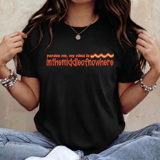Person wearing a black t-shirt with orange text and flames design. funny quote shirt, sarcastic t shirt, unisex graphic tee, humor tee, funny saying shirt, casual quote shirt, statement tee, laid back shirt, daydreaming shirt, witty t shirt, gift idea shirt, funny unisex tee, everyday graphic tee, relaxed style shirt, humorous apparel