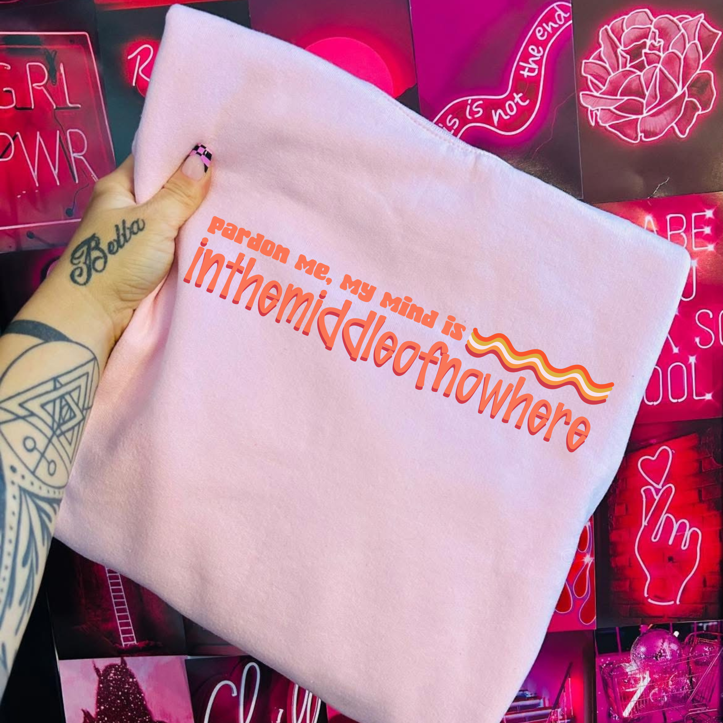 Neon sign with text 'Pardon me, my mind is in the middle of nowhere' held by a hand against a neon-lit background. funny quote shirt, sarcastic t shirt, unisex graphic tee, humor tee, funny saying shirt, casual quote shirt, statement tee, laid back shirt, daydreaming shirt, witty t shirt, gift idea shirt, funny unisex tee, everyday graphic tee, relaxed style shirt, humorous apparel