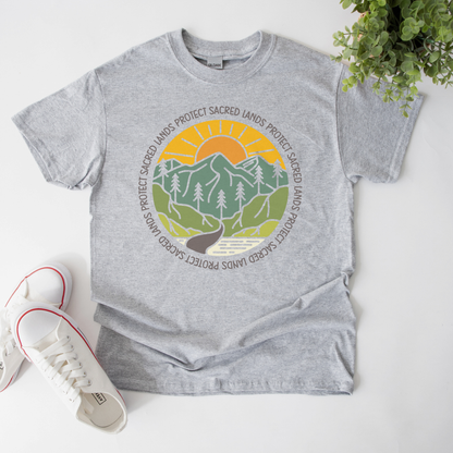 Protect Sacred Lands shirt featuring mountains, trees, water, and a rising sun surrounded by the words Protect Sacred Lands in a circular design. Protect Sacred Lands Shirt, Indigenous Advocacy Shirt, Environmental Awareness Shirt, Nature Conservation Apparel, Indigenous Land Stewardship, Protect The Land Shirt, Outdoor Graphic Tee, Conservation Clothing, Indigenous Ally Apparel, Nature Lover Gift