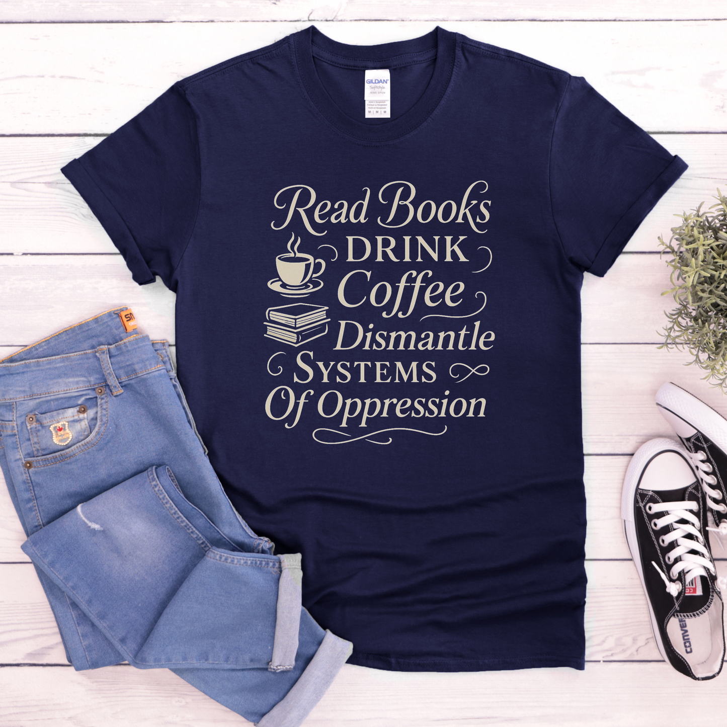 Navy blue t-shirt with motivational quote on a wooden surface with jeans and sneakers. read books drink coffee dismantle systems of oppression shirt, activist shirt, book lover shirt, coffee lover tee, social justice shirt, political statement tee, feminist shirt, progressive apparel, reader shirt, library shirt, protest shirt, anti oppression shirt, unisex graphic tee, outspoken clothing, education and activism shirt
