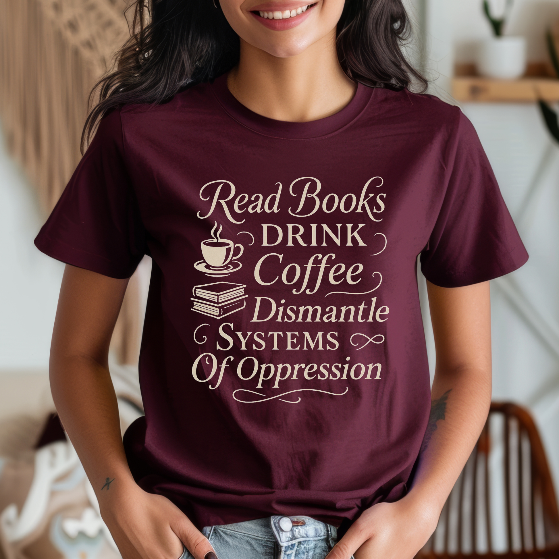 Person wearing a maroon t-shirt with motivational text in a home setting. read books drink coffee dismantle systems of oppression shirt, activist shirt, book lover shirt, coffee lover tee, social justice shirt, political statement tee, feminist shirt, progressive apparel, reader shirt, library shirt, protest shirt, anti oppression shirt, unisex graphic tee, outspoken clothing, education and activism shirt