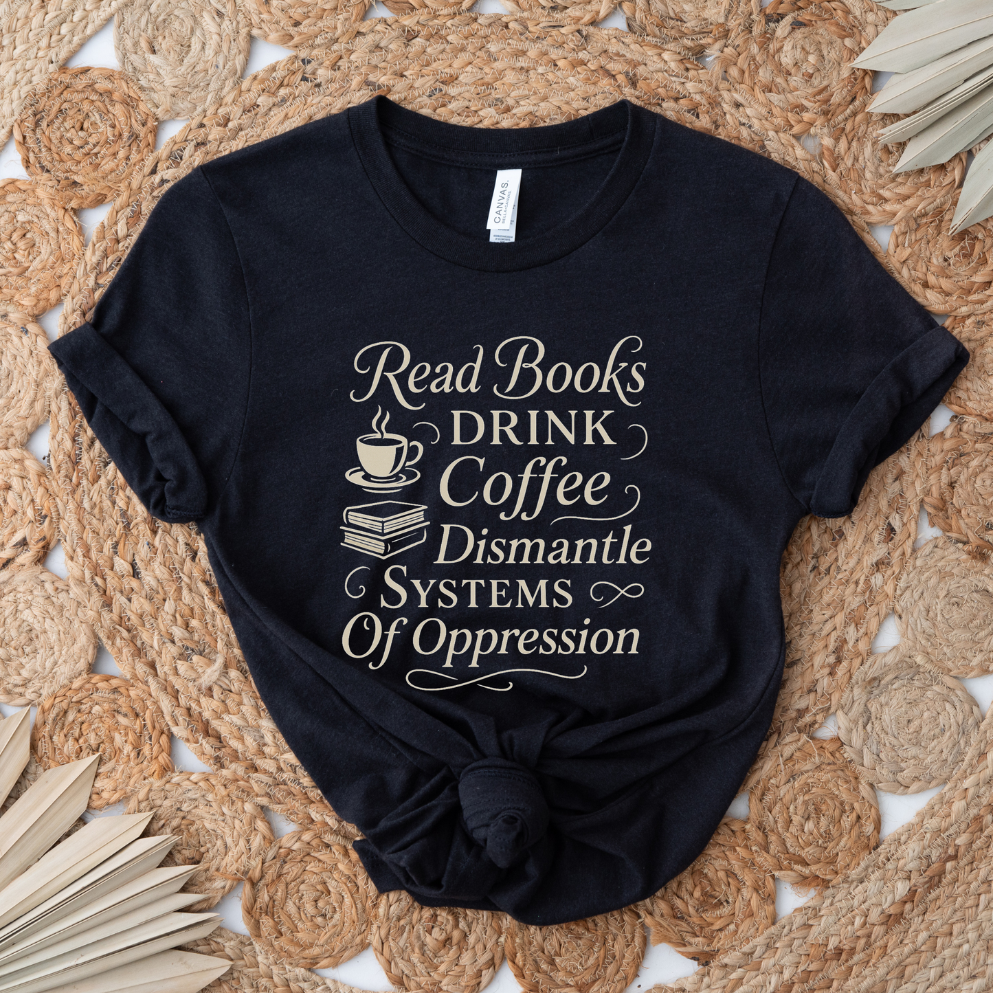 Black t-shirt with white text on a woven mat background. read books drink coffee dismantle systems of oppression shirt, activist shirt, book lover shirt, coffee lover tee, social justice shirt, political statement tee, feminist shirt, progressive apparel, reader shirt, library shirt, protest shirt, anti oppression shirt, unisex graphic tee, outspoken clothing, education and activism shirt