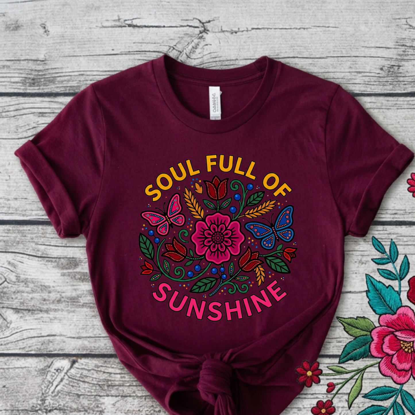 t-shirt featuring colorful Indigenous-inspired floral artwork, butterflies, and the phrase "Soul Full of Sunshine" in a vibrant circular design. soul full of sunshine shirt, Indigenous floral shirt, woodland floral shirt, butterfly shirt, floral graphic tee, colorful floral shirt, positive vibes shirt, sunshine shirt, Indigenous inspired apparel, nature lover shirt, boho floral tee, cottagecore shirt, botanical shirt, wildflower shirt, spring graphic tee, summer shirt, butterfly lover gift, floral aesthetic