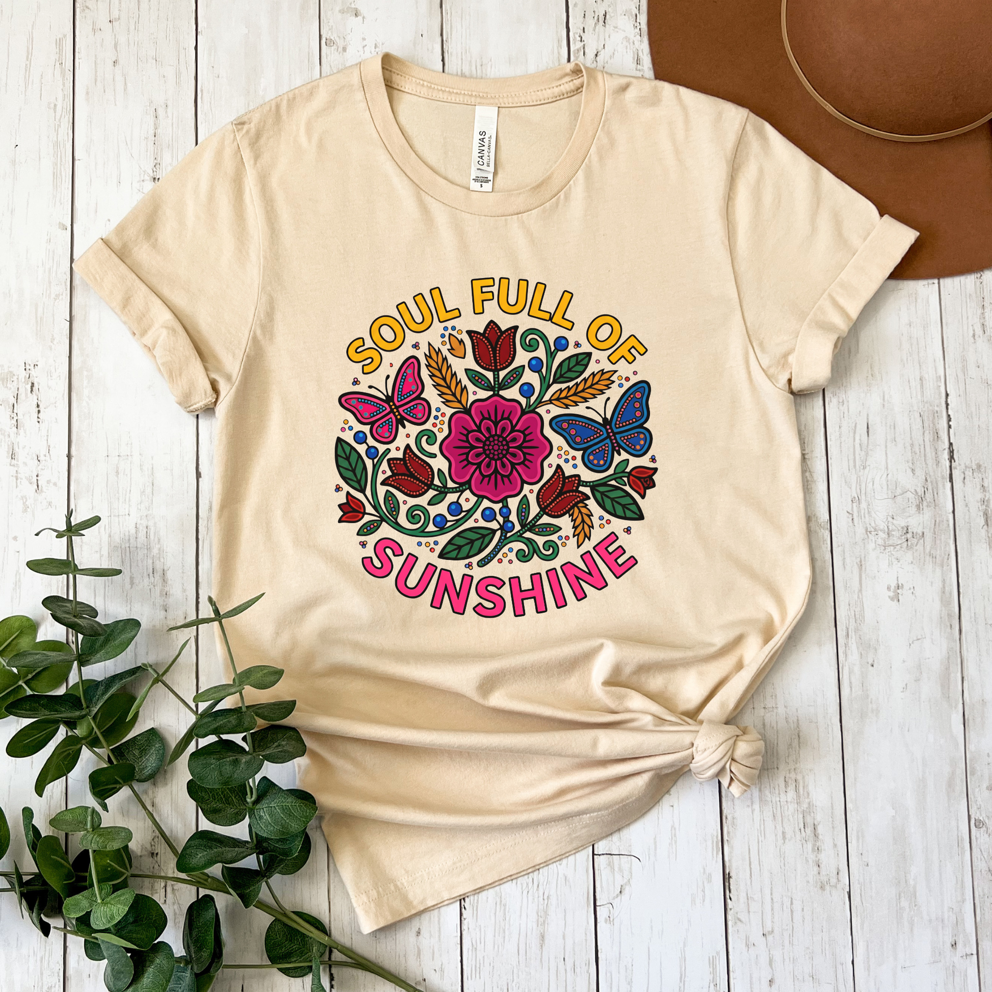 t-shirt featuring colorful Indigenous-inspired floral artwork, butterflies, and the phrase "Soul Full of Sunshine" in a vibrant circular design. soul full of sunshine shirt, Indigenous floral shirt, woodland floral shirt, butterfly shirt, floral graphic tee, colorful floral shirt, positive vibes shirt, sunshine shirt, Indigenous inspired apparel, nature lover shirt, boho floral tee, cottagecore shirt, botanical shirt, wildflower shirt, spring graphic tee, summer shirt, butterfly lover gift, floral aesthetic