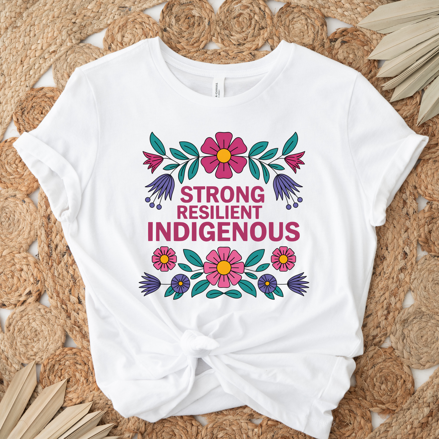 white t-shirt with colorful floral design that says strong resilient indigenous, strong resilient indigenous t-shirt, indigenous floral tee, resilience graphic shirt, indigenous empowerment apparel, floral indigenous design, unisex indigenous shirt, sahdeh spruce clothing, indigenous pride t-shirt, native resilience tee, indigenous artist design, cultural strength shirt, heritage graphic apparel