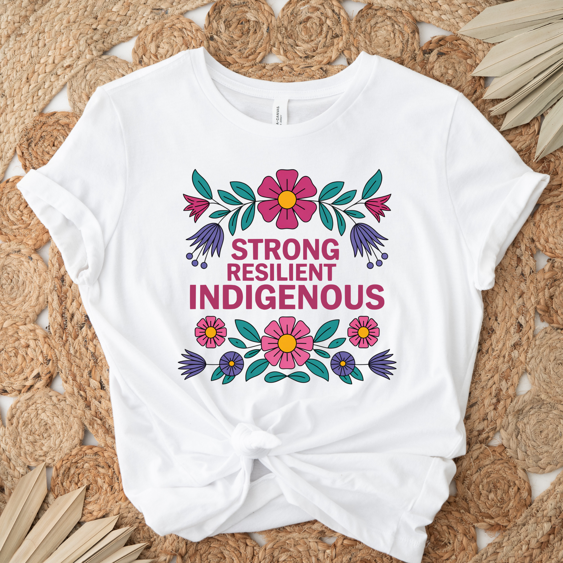 white t-shirt with colorful floral design that says strong resilient indigenous, strong resilient indigenous t-shirt, indigenous floral tee, resilience graphic shirt, indigenous empowerment apparel, floral indigenous design, unisex indigenous shirt, sahdeh spruce clothing, indigenous pride t-shirt, native resilience tee, indigenous artist design, cultural strength shirt, heritage graphic apparel