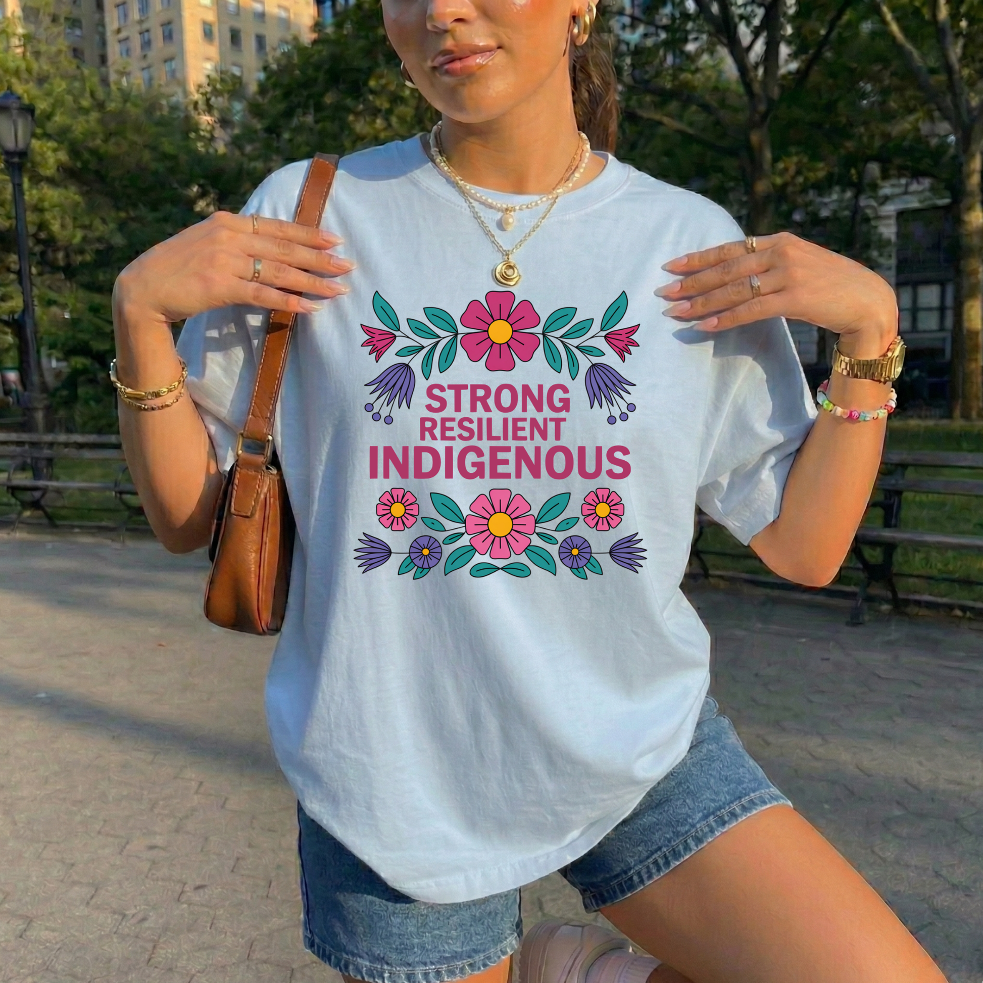 blue t-shirt with colorful floral design that says strong resilient indigenous, strong resilient indigenous t-shirt, indigenous floral tee, resilience graphic shirt, indigenous empowerment apparel, floral indigenous design, unisex indigenous shirt, sahdeh spruce clothing, indigenous pride t-shirt, native resilience tee, indigenous artist design, cultural strength shirt, heritage graphic apparel