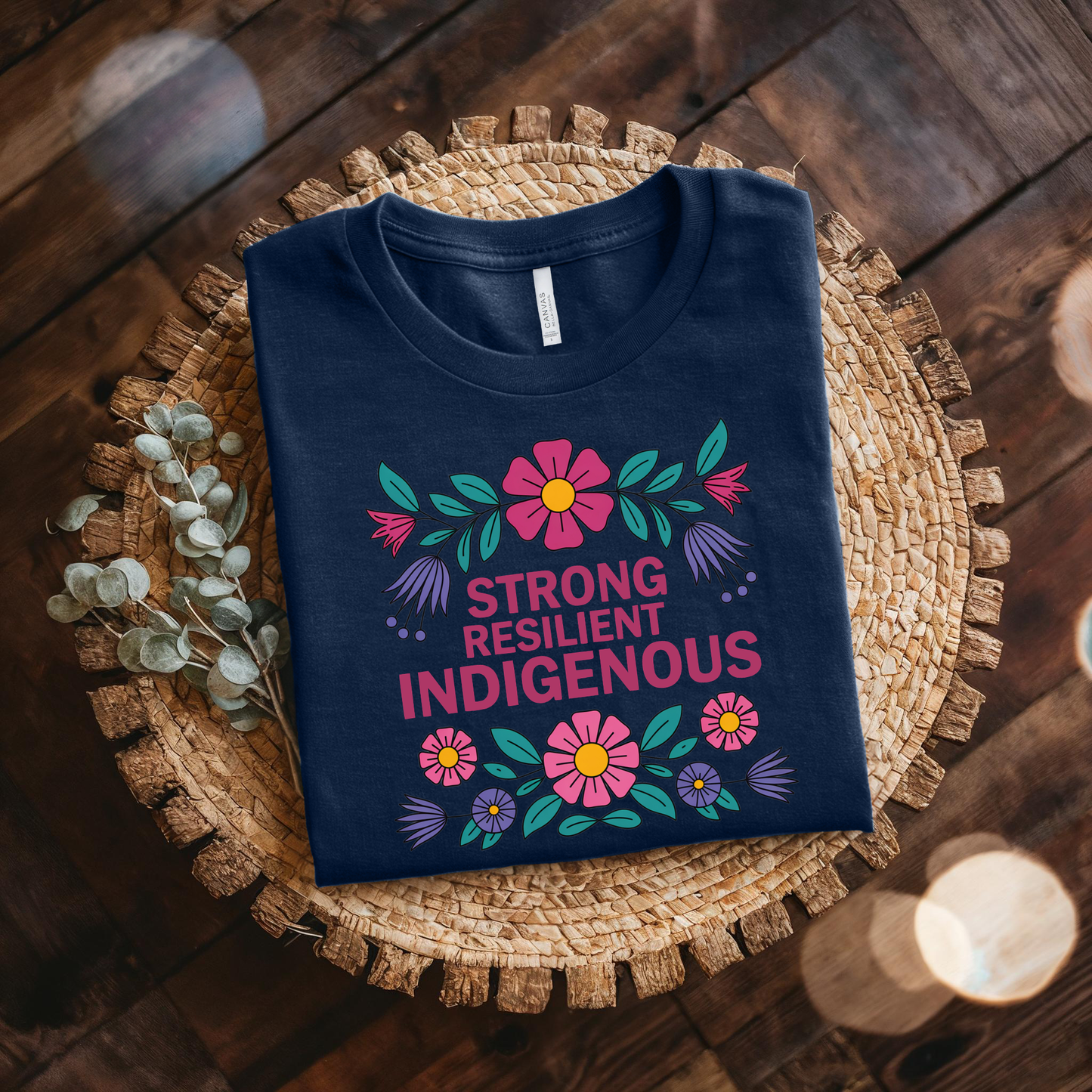 navy t-shirt with colorful floral design that says strong resilient indigenous, strong resilient indigenous t-shirt, indigenous floral tee, resilience graphic shirt, indigenous empowerment apparel, floral indigenous design, unisex indigenous shirt, sahdeh spruce clothing, indigenous pride t-shirt, native resilience tee, indigenous artist design, cultural strength shirt, heritage graphic apparel