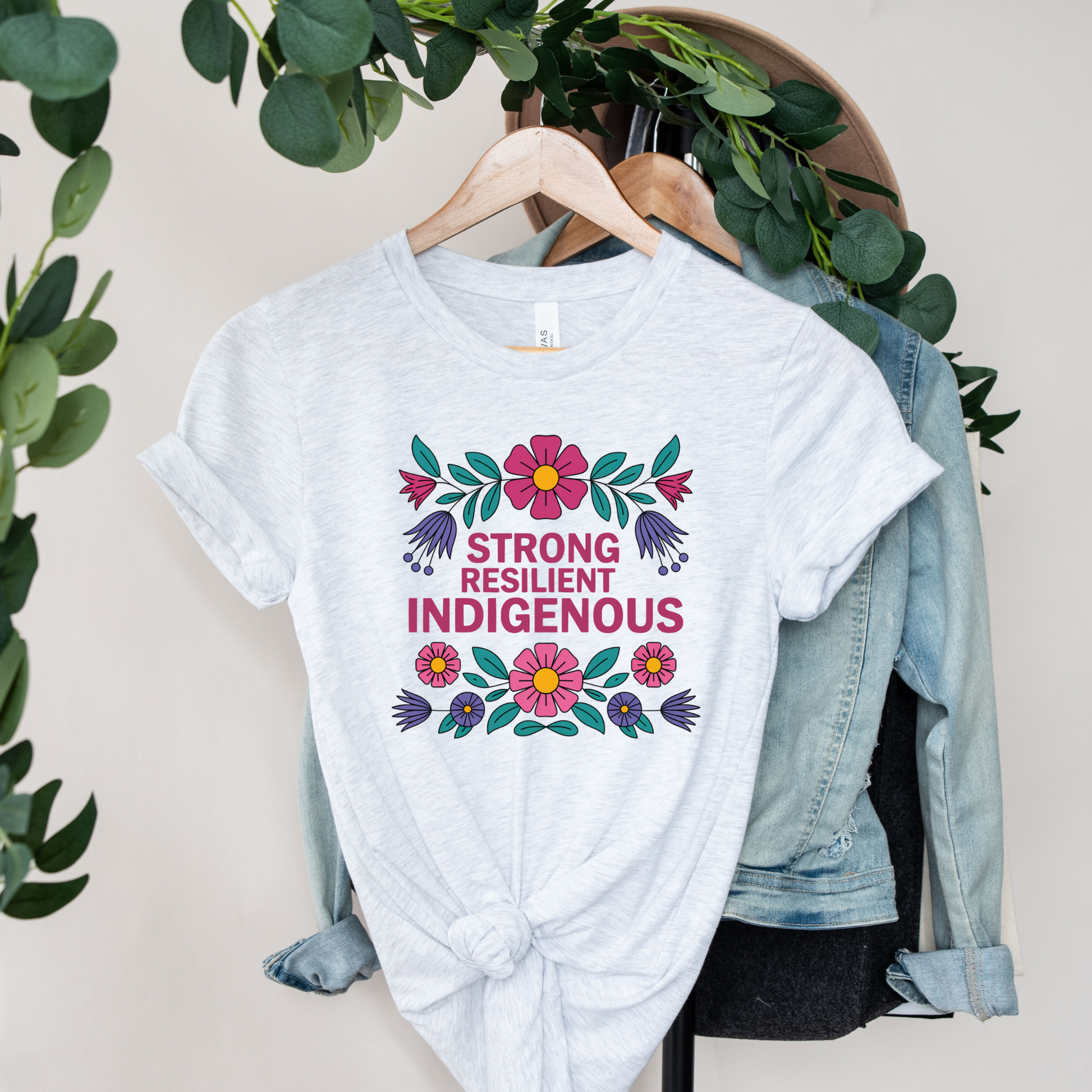 ash t-shirt with colorful floral design that says strong resilient indigenous, strong resilient indigenous t-shirt, indigenous floral tee, resilience graphic shirt, indigenous empowerment apparel, floral indigenous design, unisex indigenous shirt, sahdeh spruce clothing, indigenous pride t-shirt, native resilience tee, indigenous artist design, cultural strength shirt, heritage graphic apparel