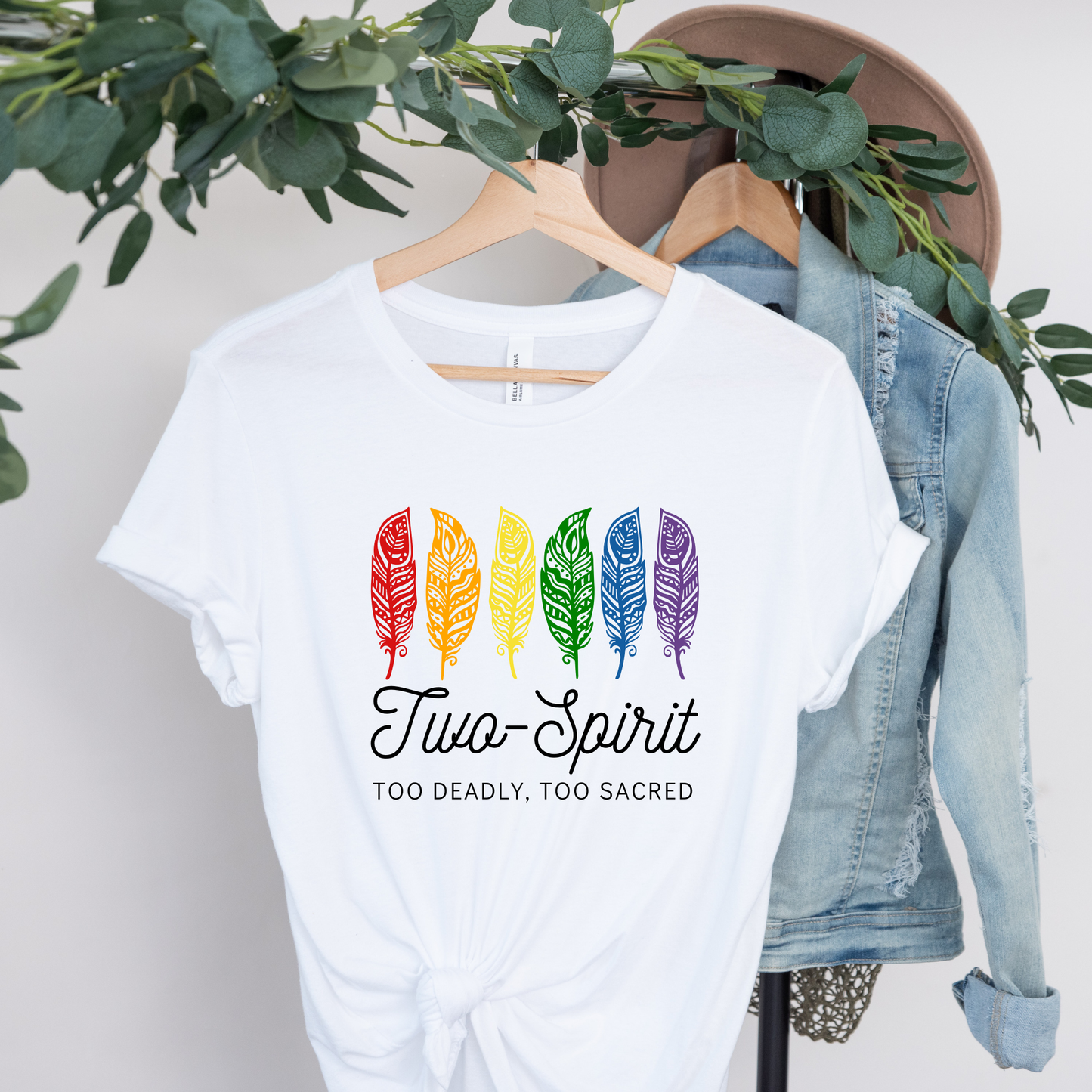 Two-Spirit Too Deadly, Too Sacred shirt with rainbow feather graphic and bold Indigenous Pride text on a unisex tee. Two-Spirit shirt, Two Spirit pride, Indigenous pride shirt, Too deadly too sacred, rainbow feather shirt, Indigenous LGBTQ tee, unisex graphic tee, Pride shirt, Two Spirit apparel, statement tee, cultural pride shirt, Indigenous owned brand, visibility shirt, sacred identity, LGBTQ Indigenous shirt