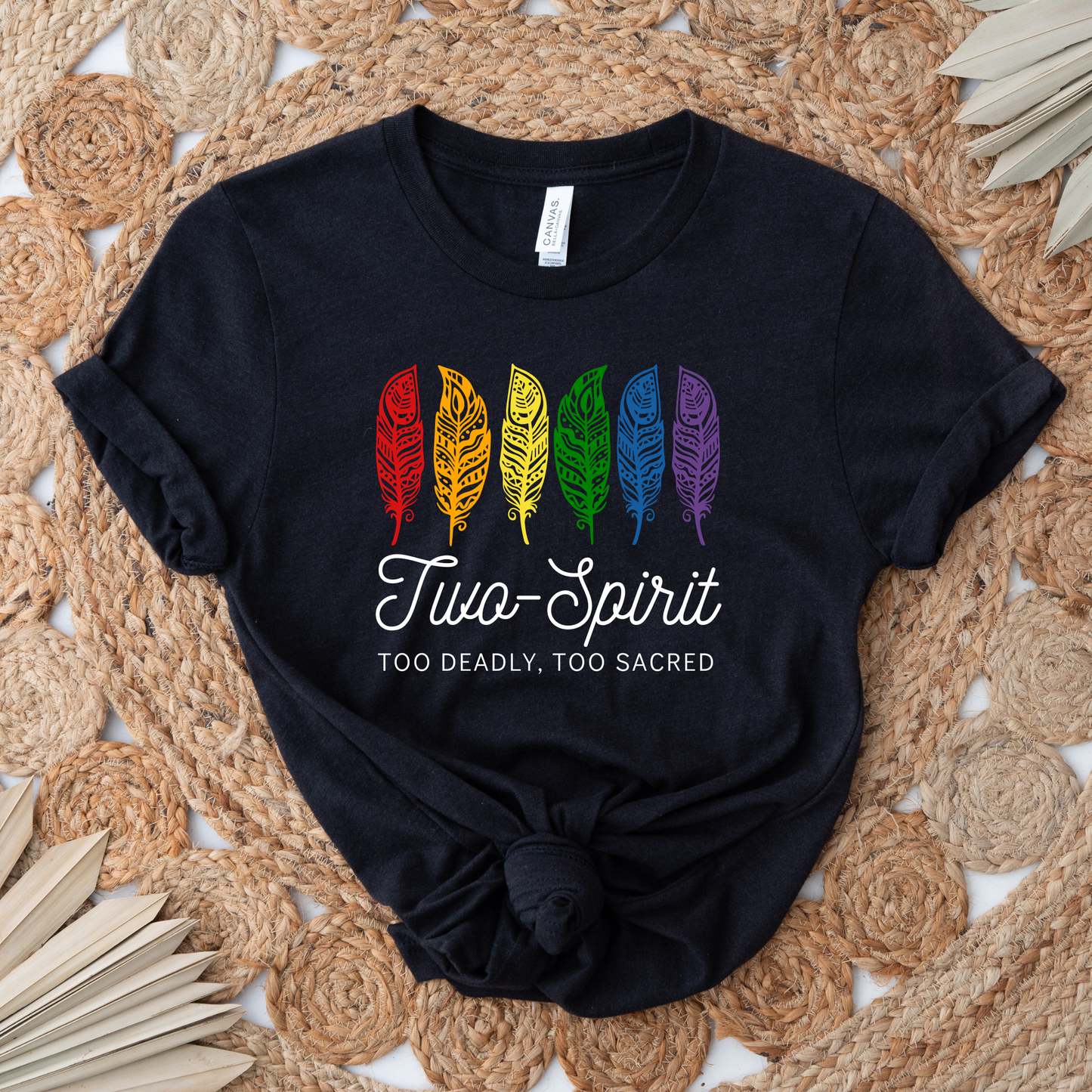 Two-Spirit Too Deadly, Too Sacred shirt with rainbow feather graphic and bold Indigenous Pride text on a unisex tee. Two-Spirit shirt, Two Spirit pride, Indigenous pride shirt, Too deadly too sacred, rainbow feather shirt, Indigenous LGBTQ tee, unisex graphic tee, Pride shirt, Two Spirit apparel, statement tee, cultural pride shirt, Indigenous owned brand, visibility shirt, sacred identity, LGBTQ Indigenous shirt