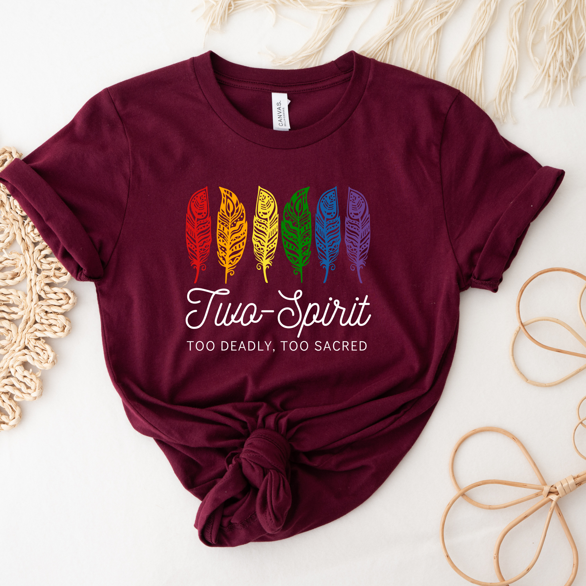 Two-Spirit Too Deadly, Too Sacred shirt with rainbow feather graphic and bold Indigenous Pride text on a unisex tee. Two-Spirit shirt, Two Spirit pride, Indigenous pride shirt, Too deadly too sacred, rainbow feather shirt, Indigenous LGBTQ tee, unisex graphic tee, Pride shirt, Two Spirit apparel, statement tee, cultural pride shirt, Indigenous owned brand, visibility shirt, sacred identity, LGBTQ Indigenous shirt