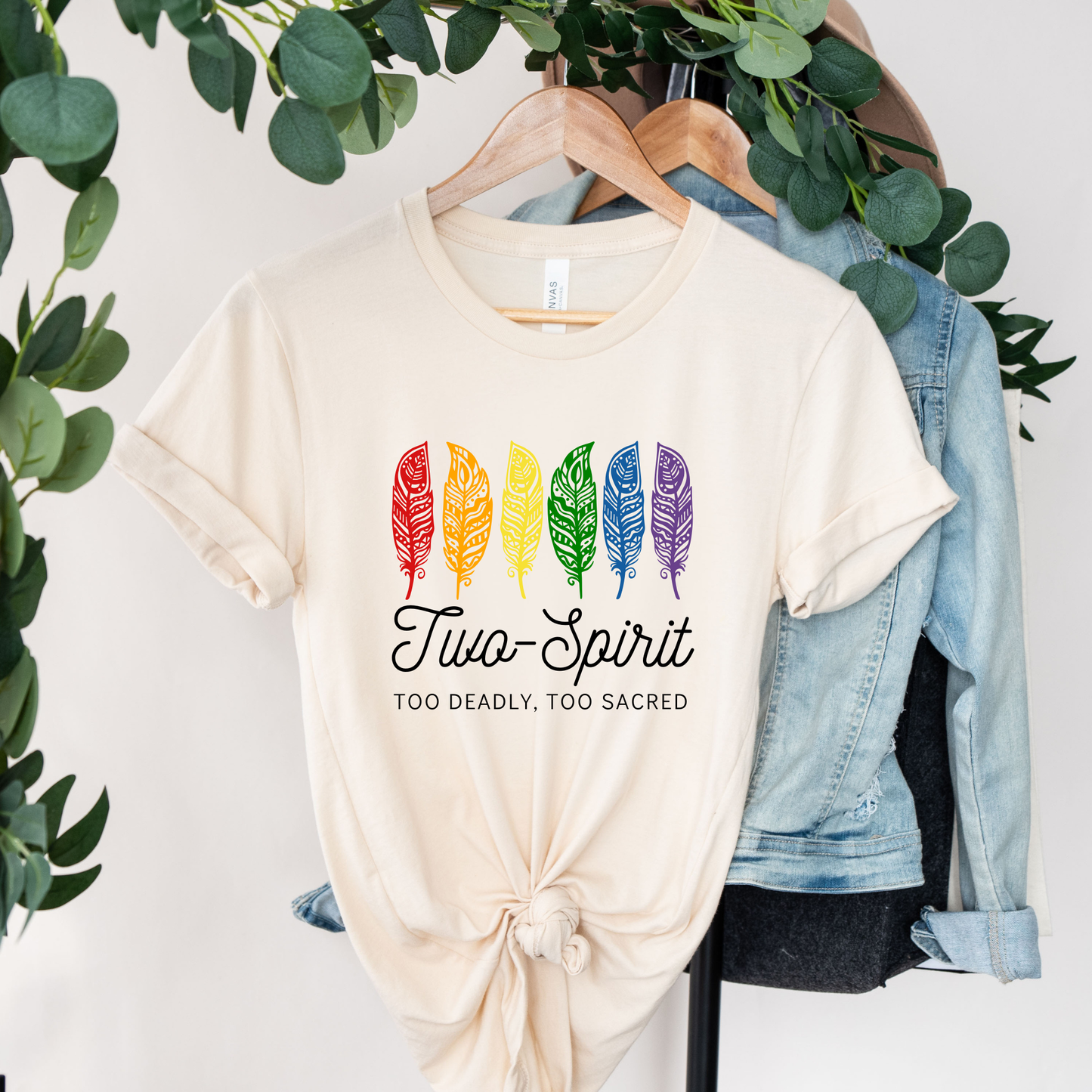 Two-Spirit Too Deadly, Too Sacred shirt with rainbow feather graphic and bold Indigenous Pride text on a unisex tee. Two-Spirit shirt, Two Spirit pride, Indigenous pride shirt, Too deadly too sacred, rainbow feather shirt, Indigenous LGBTQ tee, unisex graphic tee, Pride shirt, Two Spirit apparel, statement tee, cultural pride shirt, Indigenous owned brand, visibility shirt, sacred identity, LGBTQ Indigenous shirt