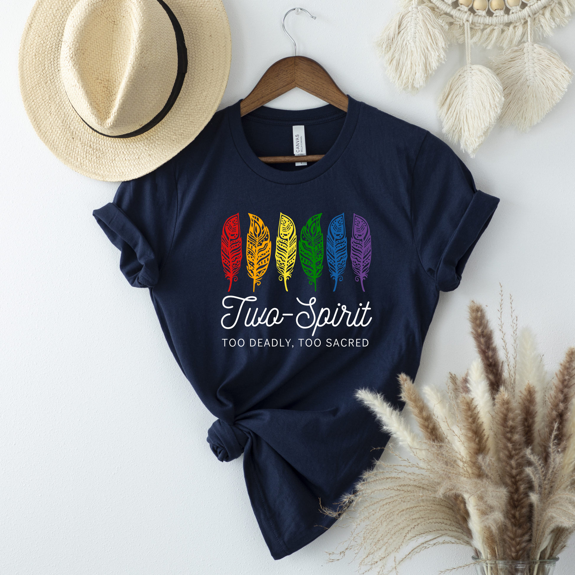Two-Spirit Too Deadly, Too Sacred shirt with rainbow feather graphic and bold Indigenous Pride text on a unisex tee. Two-Spirit shirt, Two Spirit pride, Indigenous pride shirt, Too deadly too sacred, rainbow feather shirt, Indigenous LGBTQ tee, unisex graphic tee, Pride shirt, Two Spirit apparel, statement tee, cultural pride shirt, Indigenous owned brand, visibility shirt, sacred identity, LGBTQ Indigenous shirt