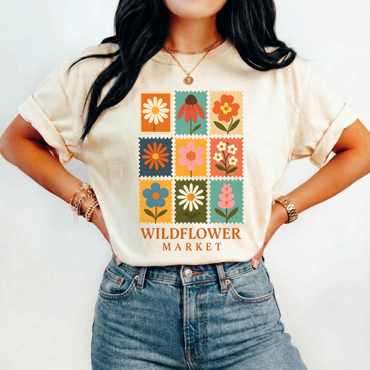 graphic t-shirt featuring colourful vintage-style floral stamp illustrations with Wildflower Market text underneath. Wildflower Market Shirt, Floral Graphic Tee, Flower Market Shirt, Cottagecore Shirt, Botanical T-Shirt, Wildflower Tee, Vintage Floral Shirt, Garden Lover Gift, Nature Inspired Apparel, Retro Flower Shirt