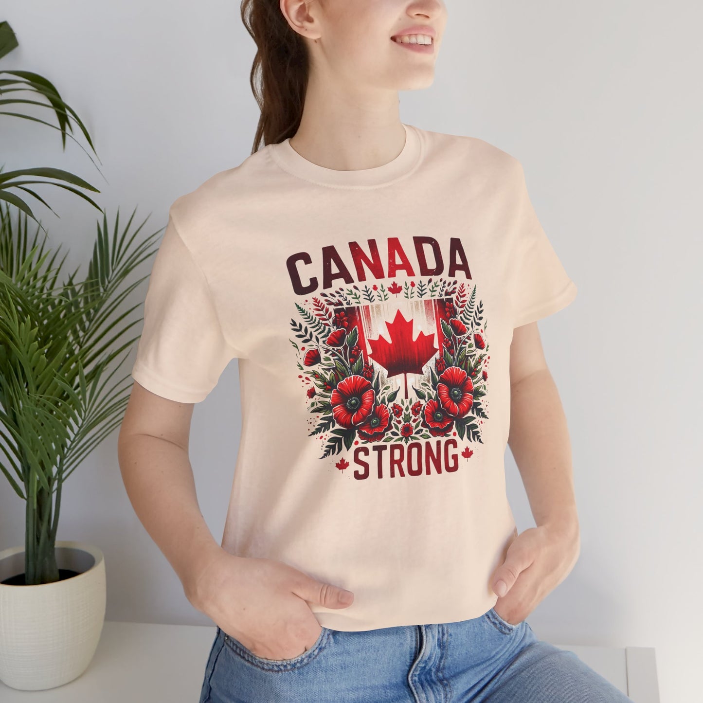Canada Strong shirt featuring a red Canadian maple leaf surrounded by vibrant red flowers and greenery with bold Canada Strong text. Proudly made in Canada, this patriotic floral graphic tee celebrates Canadian pride, resilience, and unity.