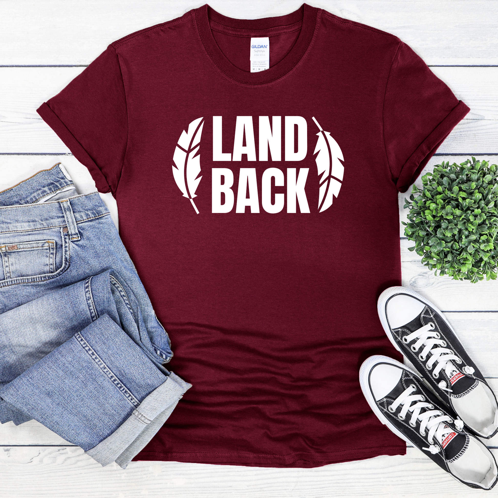 Land Back shirt featuring bold white lettering framed by two feathers, representing Indigenous sovereignty and Indigenous rights.land back shirt, indigenous shirt, indigenous rights shirt, indigenous sovereignty shirt, land back movement, decolonization shirt, indigenous advocacy apparel, indigenous activist shirt, truth and reconciliation shirt, orange shirt day apparel, national indigenous peoples day shirt, indigenous pride shirt, ally shirt, feather shirt, indigenous graphic tee, native rights shirt
