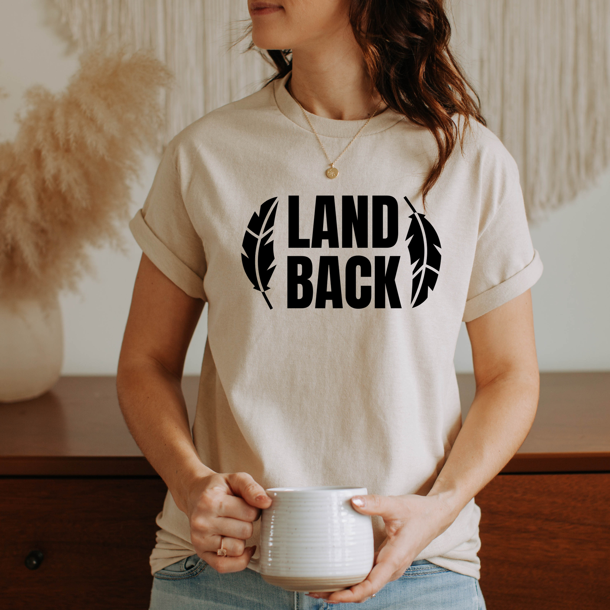 Land Back shirt featuring bold white lettering framed by two feathers, representing Indigenous sovereignty and Indigenous rights.land back shirt, indigenous shirt, indigenous rights shirt, indigenous sovereignty shirt, land back movement, decolonization shirt, indigenous advocacy apparel, indigenous activist shirt, truth and reconciliation shirt, orange shirt day apparel, national indigenous peoples day shirt, indigenous pride shirt, ally shirt, feather shirt, indigenous graphic tee, native rights shirt