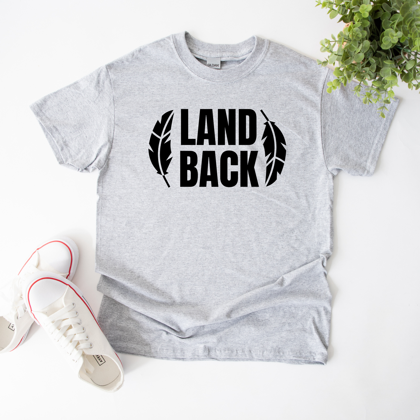 Land Back shirt featuring bold white lettering framed by two feathers, representing Indigenous sovereignty and Indigenous rights.land back shirt, indigenous shirt, indigenous rights shirt, indigenous sovereignty shirt, land back movement, decolonization shirt, indigenous advocacy apparel, indigenous activist shirt, truth and reconciliation shirt, orange shirt day apparel, national indigenous peoples day shirt, indigenous pride shirt, ally shirt, feather shirt, indigenous graphic tee, native rights shirt