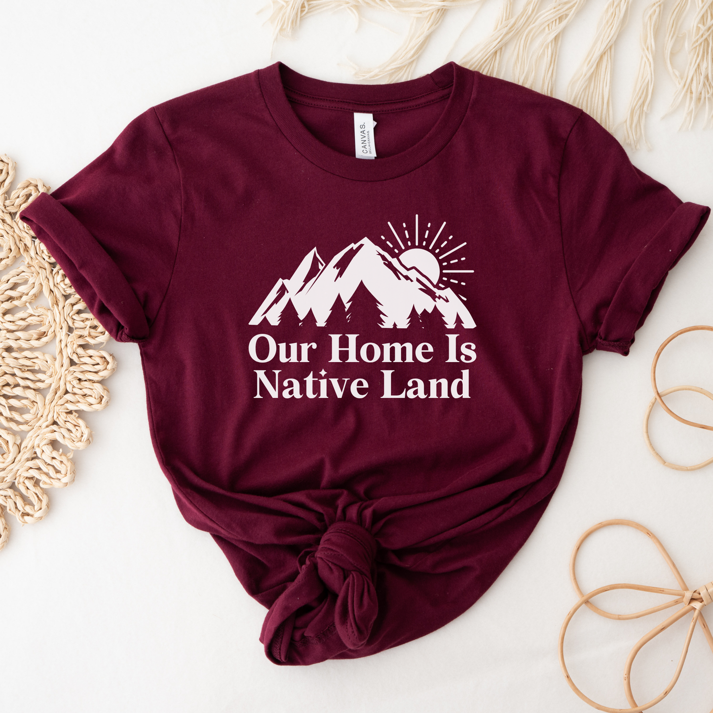 Our Home Is Native Land shirt with white mountain and sunrise graphic on a unisex t-shirt. our home is native land shirt, indigenous pride tee, native pride shirt, indigenous apparel, unisex graphic tee, land acknowledgment shirt, indigenous awareness shirt, statement tee, mountain sunrise shirt, everyday wear shirt, community event shirt, indigenous clothing, native land shirt, meaningful graphic tee, cultural pride shirt