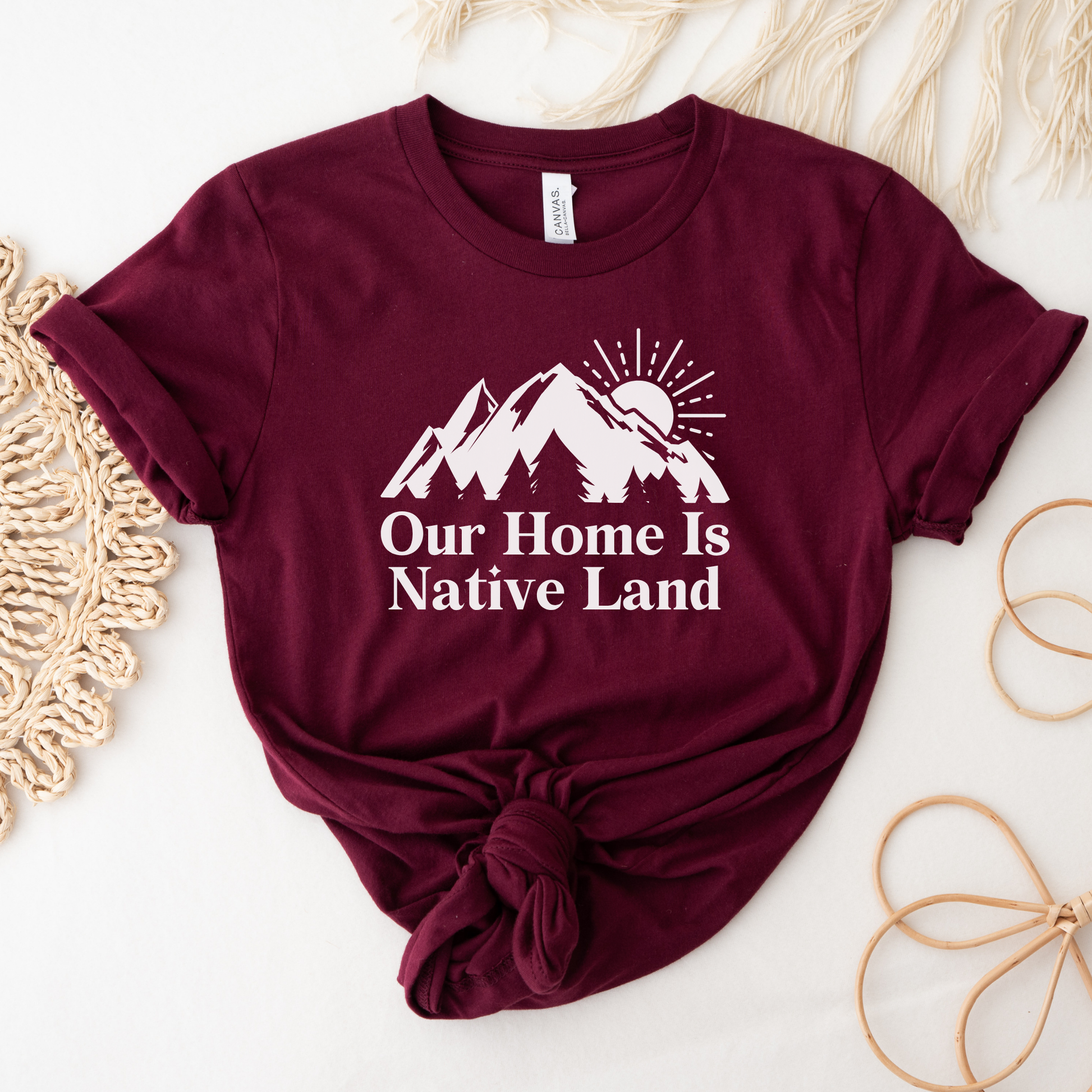 Our Home Is Native Land shirt with white mountain and sunrise graphic on a unisex t-shirt. our home is native land shirt, indigenous pride tee, native pride shirt, indigenous apparel, unisex graphic tee, land acknowledgment shirt, indigenous awareness shirt, statement tee, mountain sunrise shirt, everyday wear shirt, community event shirt, indigenous clothing, native land shirt, meaningful graphic tee, cultural pride shirt