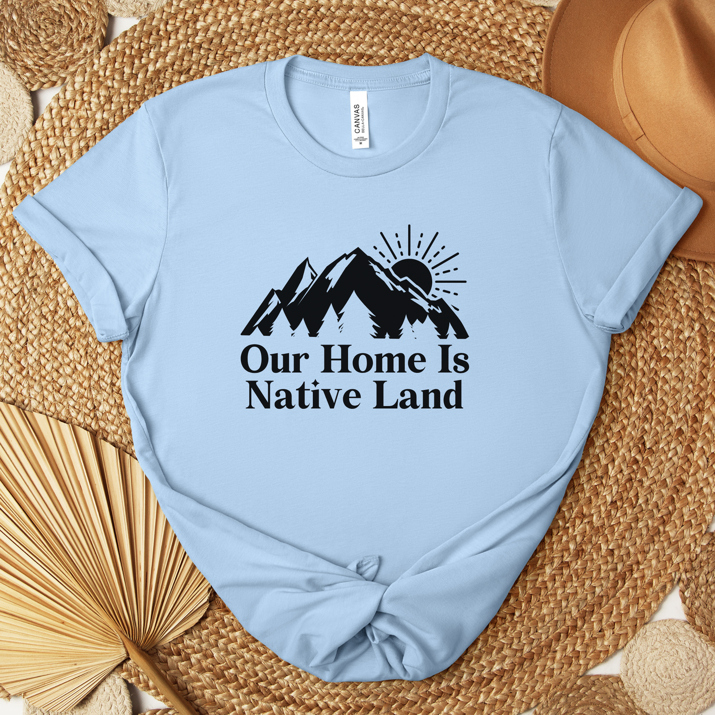 Our Home Is Native Land shirt with white mountain and sunrise graphic on a unisex t-shirt. our home is native land shirt, indigenous pride tee, native pride shirt, indigenous apparel, unisex graphic tee, land acknowledgment shirt, indigenous awareness shirt, statement tee, mountain sunrise shirt, everyday wear shirt, community event shirt, indigenous clothing, native land shirt, meaningful graphic tee, cultural pride shirt