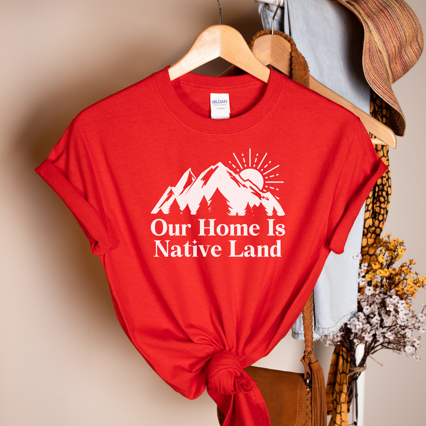 Our Home Is Native Land shirt with white mountain and sunrise graphic on a unisex t-shirt. our home is native land shirt, indigenous pride tee, native pride shirt, indigenous apparel, unisex graphic tee, land acknowledgment shirt, indigenous awareness shirt, statement tee, mountain sunrise shirt, everyday wear shirt, community event shirt, indigenous clothing, native land shirt, meaningful graphic tee, cultural pride shirt