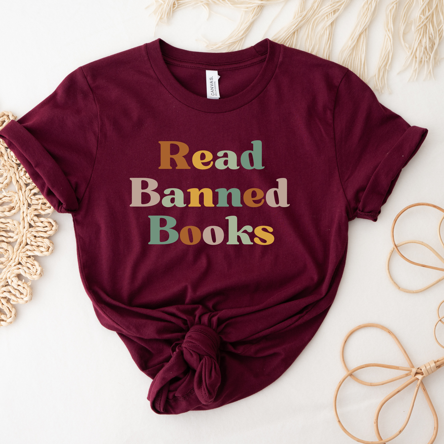 Maroon t-shirt with 'Read Banned Books' text on a light background. read banned books shirt, banned books tee, book lover shirt, librarian shirt, teacher book shirt, freedom to read shirt, literary shirt, bookish apparel, reading shirt, library activism shirt, anti censorship shirt, intellectual freedom tee, book club shirt, educational shirt, reader gift shirt