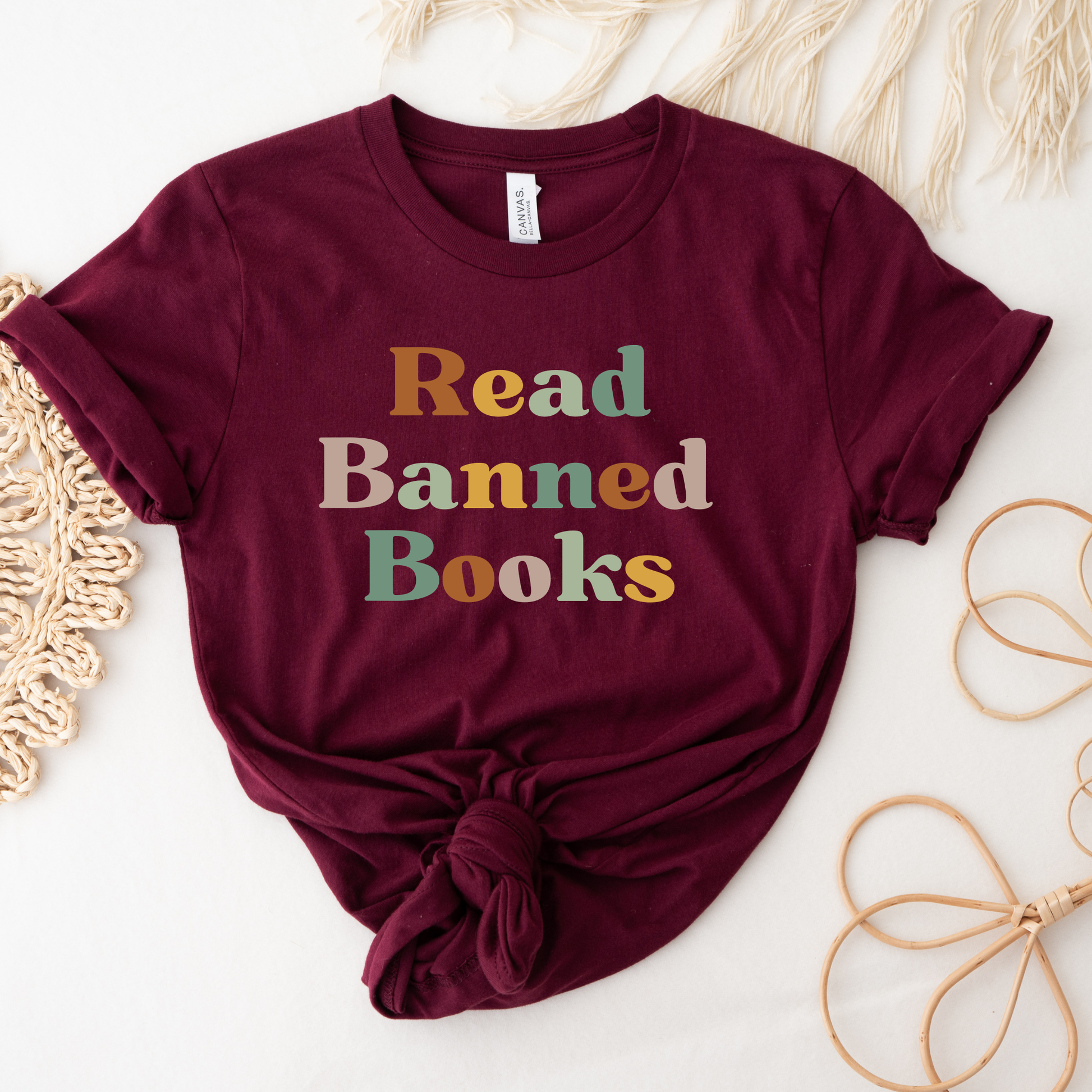 Maroon t-shirt with 'Read Banned Books' text on a light background. read banned books shirt, banned books tee, book lover shirt, librarian shirt, teacher book shirt, freedom to read shirt, literary shirt, bookish apparel, reading shirt, library activism shirt, anti censorship shirt, intellectual freedom tee, book club shirt, educational shirt, reader gift shirt