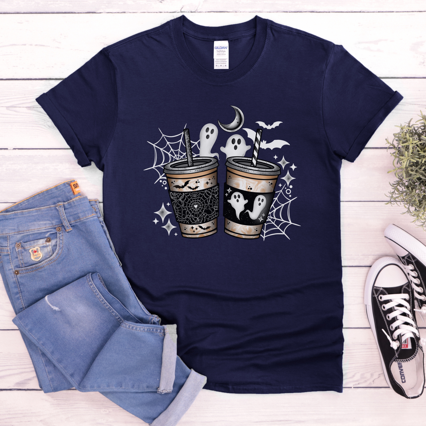 Navy blue t-shirt with a graphic design of three women in red dresses and 'MMIW' text, placed on a wooden surface with jeans and sneakers. ghost coffee shirt, spooky coffee shirt, halloween coffee tee, cute ghost shirt, spooky season shirt, pumpkin spice shirt, fall coffee lover, halloween graphic tee, ghost aesthetic shirt, coffee lover gift, cozy fall outfit, pumpkin patch shirt, autumn halloween tee